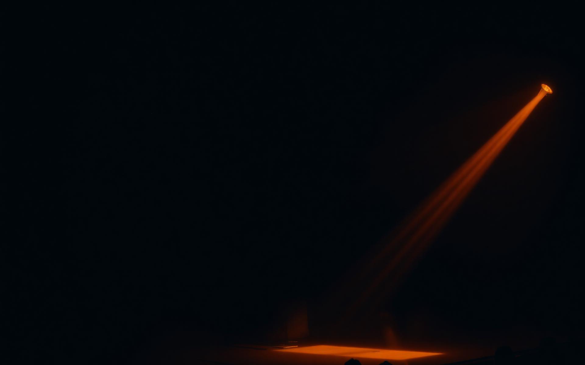 Stage light spilling across a darkened concert hall
